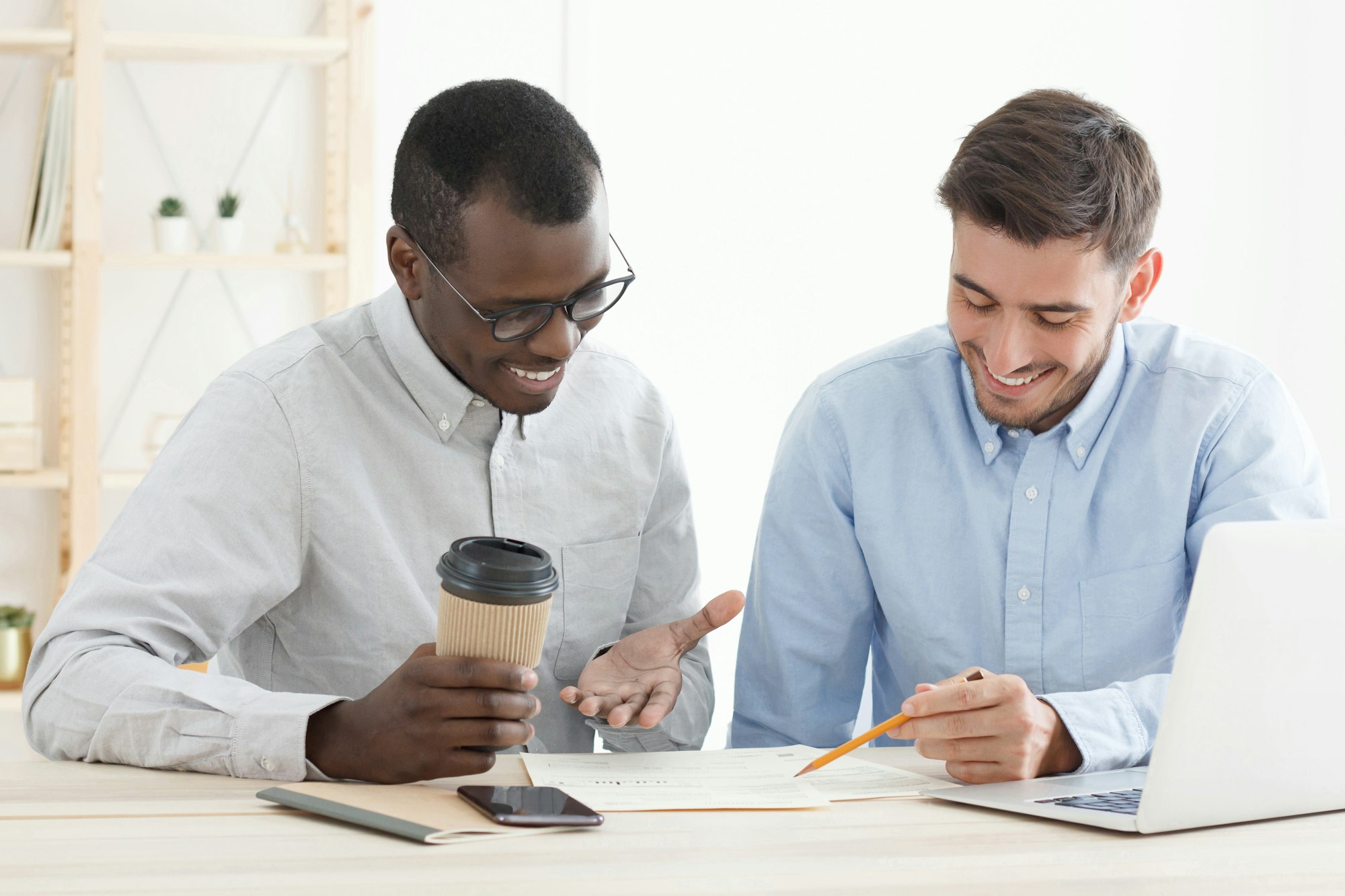 Diversity in education concept. Caucasian male teacher supporting his african adult student